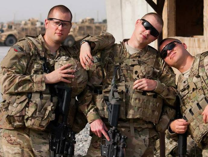 The founder in the middle of a group photo with two fellow soldiers.